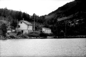 Lite kvitt skulehus sett frå fjorden. Bygd i 1892. Registrering utført 1958-59 av Johan Schiong for Norsk Lærarlag.