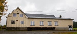 Forsamlingslokalet Skogtun i Snertingdal. En gul lang bygning.