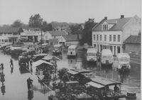 Tomta i regnversdrakt med torghandel m.m. Bildet tatt i 1949, Busskafèen er bort. Bildet tatt fra Sigurd Andersen vindu.