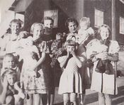 Fra bursdagsselskapet. Barn med bamser på andre siden av huset. Bursdagsbarnet til høyre og til venstre for henne lillesøster Aud Gerd. Foto: Ukjent, 1940.