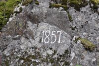 Årstallet 1857 hogd inn i fjellveggen i Kviteseidkleivane. Det var året vegen her opna. Foto: Roy Olsen (2022).