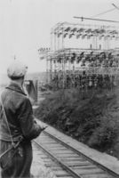 Hjemmefrontsoldat med stengun holder vakt ved Flesaker tranformatorstasjon i mai 1945. Flesaker utenfor Vestfossen distribuerte kraften fra Nore kraftverk i Numedal og var ett av knutepunktene i kraftforsyningen på Østlandet. For hjemmefronten på Eiker var en av de høyeste prioriterte oppgavene etter fredsslutningen å sikre dette anlegget mot sabotasje. Bildet tilhører Sverre Kristiansen. Fra Eiker arkiv.