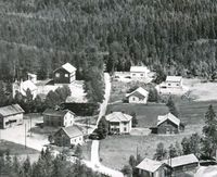 Framme til venstre Veum Handelslag, deretter mot høgre Kyrkjestoga med kyrkjestallane bak. Vidare mot høgre bedehuset. Foto 1947