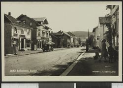 Bok- og papirhandelen lå i huset lengst til venstre på dette bildet, som er tatt mens den var i drift. Foto: Ukjent / Nasjonalbiblioteket