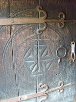 Dør med beslag i smijarn og treskurd. Foto: Olve Utne (2008).