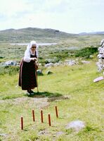 Bilete 13: Anne spelar ringspel på Ustaoset, der både Tufto og Vindegg hadde stølar. Til høgre skimtar me ei steinbu, lik den ho budde i då ho var med på stølen i Uri som liten. Foto: Ingebjørg Vindegg, 1970-talet.