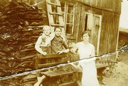 Arne Hoel og moren Julie og gutt i uthusveggen på Stubberud.