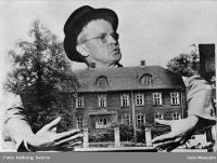 Arno Berg fotografert med et bilde av Militærhospitalet i Oslo, som han hadde engasjert seg for å bevare. Foto: Sverre Heiberg (1972)