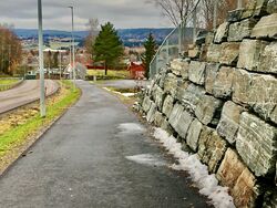 Avkjøring til Breidablikk barnehage nedenfor muren. 2023.