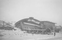Den sammenraste hangarhalvdelen med betongbuen for takkonstruksjonen, som gikk på tvers av portåpningen. Foto: Finn Rifseim (KFF).