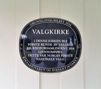 Plakett ved Biri kirke, som var valgkirke i 1814. Foto: Trond Nygård (2019).