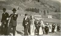 Brurefølgjet til Sigurd Selvik og Anna Mjelde i 1939 passerer straks Leisteinen. Hansdalstunet i bakgrunnen. Fotograf Berta Bergsvik. Frå privat samling.