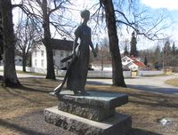 Statue av den unge Camilla Collett utenfor Eidsvoll kirke, utført av Ada Madsen (1977). Foto: Stig Rune Pedersen