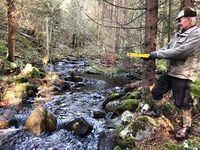 Damsted Lundsfløtten. Hans Georg Molvig indikerer dammens opprinnelige høyde med det gule wateret.