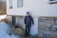 Eystein Røset ved Langmo gård i Gratangen. Her viser han hvor han gjemte seg etter å ha blitt skadeskutt under trefningene 25. april 1940. Foto: Fotogjeteren