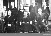 Bilete 4: Mari omkransa av sju av borna i Søre Juvsjordet. Som mora har Anne (øvst i midten) konehette, så biletet kan tidlegast vera frå 1911, då ho gifte seg. To av brørne har også hallingklede. Ukjent fotograf, Hol bygdearkiv.