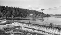 Fermettedam i Mørkfoss, dammen ble demmet ned i 1924 i forbindelse med at Solbergfoss kraftverk fem km ned i elva åpnet. Foto: Johs. Johannessen/Norsk Skogmuseum (1914).