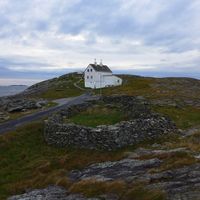 Fyrmesterboligen med fyrmesterkona kjøkkenhage i forgrunnen.