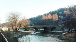 Broen sett på avstand østover med Rønne elv i forkant. Foto: Pål Giørtz (2021).