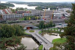Folangerveien krysser Rønne elv over Folangerbroen som er utformet sammen med rundkjøringene på hver elvebredd. Foto: AB-leksikon
