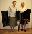 Aslaug og Ragnhild viser fram bunadsforkle.