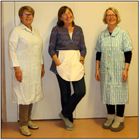 Tone har på seg eit nylonforkle. Gudrun har klypeforkle. Bjørg har eit kjoleforkle av stripete bomullstoff.