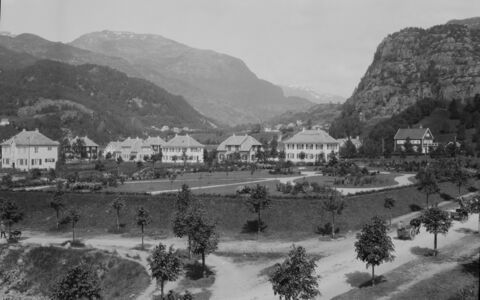 Dette biletet gir eit inntrykk av parken ein gong på 1920-talet. Her har trea i parken ikkje rukke å veksa seg høge. Det gjer at ein ser tydeleg stukturane i parken med ulike platningar og grupperingar av busker og bloma. Foto: Kunstforlaget Mittet & Co. A/S (Nasjonalbiblioteket)