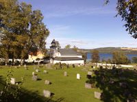 Gjøvik kirkegård og gravkapell ligger på nersida av vegen, ned mot Mjøsa.