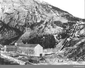 Det nyoppførte kraftverket med rørgate og det provisoriske kraftverket i forgrunnen. Foto: Bernt Lund/Nordlandsmuseet (1920).