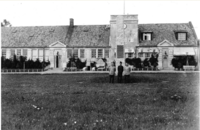 Hærens flyskoles bygg, «tårnbygget», reist 1923. I forgrunnen bautaen over falne.