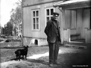 Hans Ramton foran hovedhuset på Ramton med hunden Tullik på 1930-tallet. Han drev gården da det var omfattende isdrift. Fotograf ukjent.