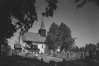 Kirken sett fra gravlunden mot sørvest. Foto: Nasjonalbiblioteket (1949).