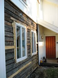 Her er gammel tømmervegg frilagt ved inngangspartiet i fasade vest mot Sagdalsveien.