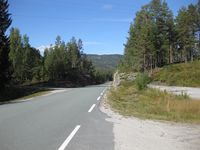Fylkesvegen sett mot nord, den gamle vegen svingar rundt bergryggen til venstre.