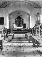 Interiøret i kirka rundt århundreskiftet. Legg merke til den halvåpne døra som leder inn til sakristiet i apsis, og nyprekestolen fra 1880. Foto: Fredrik Schreiner.