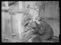 Mann fyrer i vedovnen. Foto: Narve Skarpmoen, Nasjonalbiblioteket, 1899-1930.