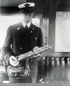 Holmenkollbanen, billettør med lang billettholder. Ukjent/Oslo Byarkiv