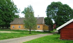 Huseby gård 2012. Hovedbygningen med smia i forgrunnen.