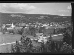 Innbygda med Kirkebrua over Trysilelva. Foto: Ukjent / Nasjonalbiblioteket