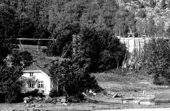 Den steinhaugen vi ser i strandkanten i dag er restene etter den borteste av de to fortøyningskarene til høyre på dette bildet fra 1893-1898. (Utsnitt av foto fra AS Søndre Nærsnes)