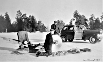 Slutten av 1940-tallet Isskjæring på Vest-dammen på Høvikvollen i Båtstø. Elektrisk drevet issag. Aggregatet sto plassert i ishuset. Ved issaga er Christian Høvik, eier av Sole og eier av Vest-dammen. T.h. er Fredrik Høvik.(Fotograf ukjent) .