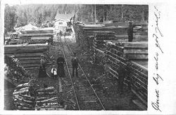 Iveland med plankestabler klare for videretransport. Ukjent/Postkort