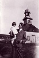 Louise på farens arm foran klokketårnet på Fossesholm.