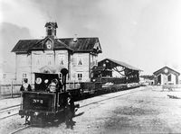 Damplokomotiv type I nr. 2 med Hamars første stasjonsbygning, toghallen og lokomotivstallen i bakgrunnen 1862. Kilde Jernbanemuseet.