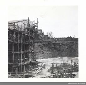 Byggingen i juli 1951: Tribunen mot vest reiser seg, de to takgavlene bak er Kampen skole. Foto: Arbeiderbevegelsens arkiv og bibliotek (1951).