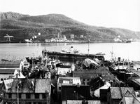 Fabrikken sett fra byen - med Storgata nr. 13, 15 og 17 i forgrunnen, så Kaarbøs Mek. Verksted med skip i dokk og på slip.