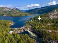 Vi ser her Glomsdammen med Glomfoss bruk til venstre og Fyresvatn som strekker seg mot nord. På odden litt oppe i vatnet ligg Lønnegrav gravplass. Foto frå 2023.