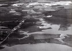 Dette bildet av en flom i 1930 viser hvor mye av flyplassområdet som etter hvert måtte fylles opp. Granasletta midt på bildet, og ”Hundremeter’n” i bakgrunnen opp mot ”Måsasvingen” og Storgata. Foto FLO Kjeller arkiv.