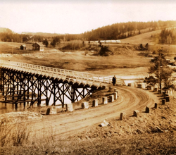 Kjellerholen bru fra 1877 i 1932. Skedsmo kirke i bakgrunnen.