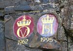 Detalj fra Kronene i Håvet i Kongsberg, monogrammene til kong Olav V fra hans besøk der i 1962, og kong Harald V, fra hans besøk i 1995.